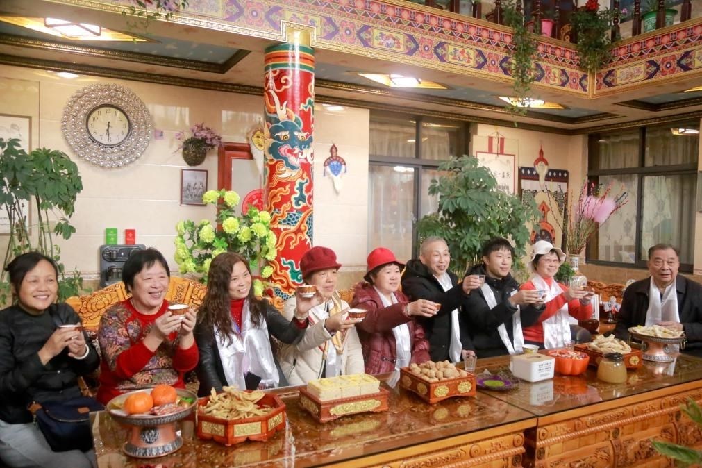 游客們?nèi)胱∶袼藓?，舉杯共飲酥油茶。新華社記者 邱星翔 攝