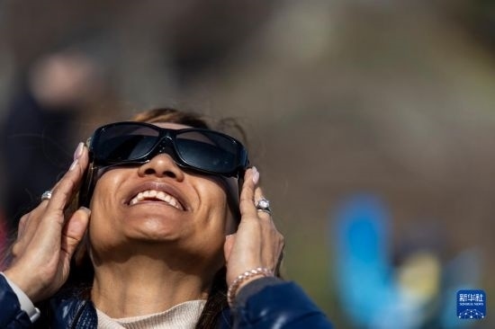 4月8日，一名女子在美國(guó)紐約州普拉茨堡觀看日食。新華社發(fā)（文森特·約翰遜攝）