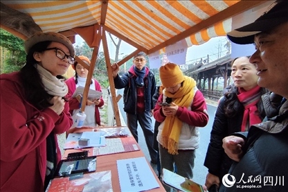 1月6日，“2024成都蒲江柑甜采摘節(jié)”上，記者見(jiàn)到了小萌（左一）和許多年輕人忙著做訪(fǎng)客接待、現(xiàn)場(chǎng)布置、票務(wù)核對(duì)、采摘服務(wù)等工作。人民網(wǎng)記者朱虹攝