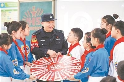 圖為公安民警給學(xué)生們講解國(guó)家安全知識(shí)。張鷹攝