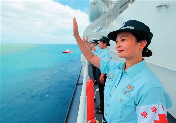 中國海軍“和平方舟”號醫(yī)院船結(jié)束訪問湯加時，任務(wù)官兵中的文職人員向歡送人群揮手告別（2023年8月4日攝）。徐巍攝/本刊