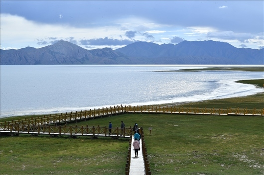 △ 游客行走在青?，敹嗫h冬格措納湖畔的木棧道上。