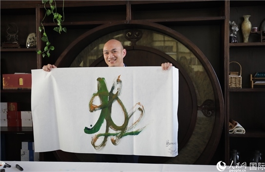 老撾駐華大使館三秘明君參加《五百筆·瀾湄合作》集體藝術(shù)創(chuàng)作。人民網(wǎng)王婧攝。