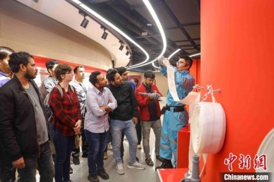 5月9日，工作人員指導(dǎo)留學(xué)生正確使用消防水帶。張鷹 攝