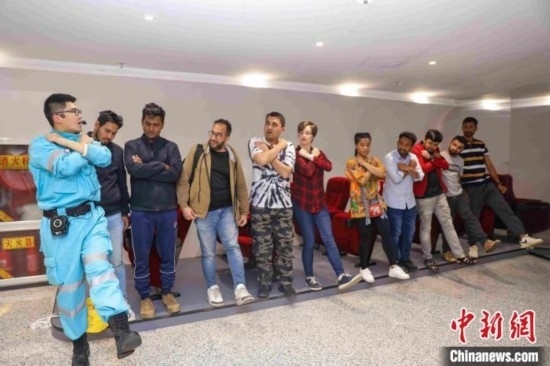 5月9日，工作人員指導(dǎo)留學(xué)生練習(xí)逃生技巧。張鷹 攝