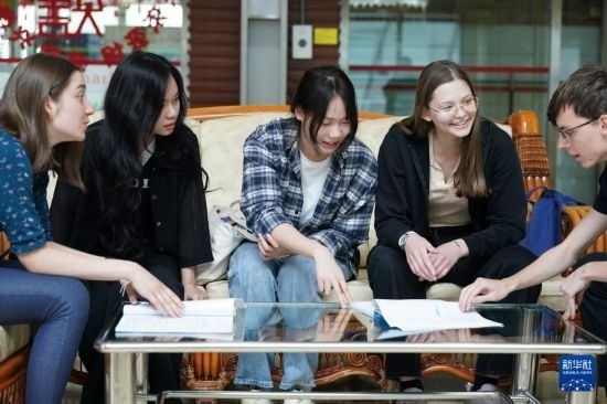 4月28日，宋智孝（右二）和胡靈月（左一）在北京首都師范大學(xué)校園內(nèi)與同學(xué)交流。新華社記者 彭子洋 攝