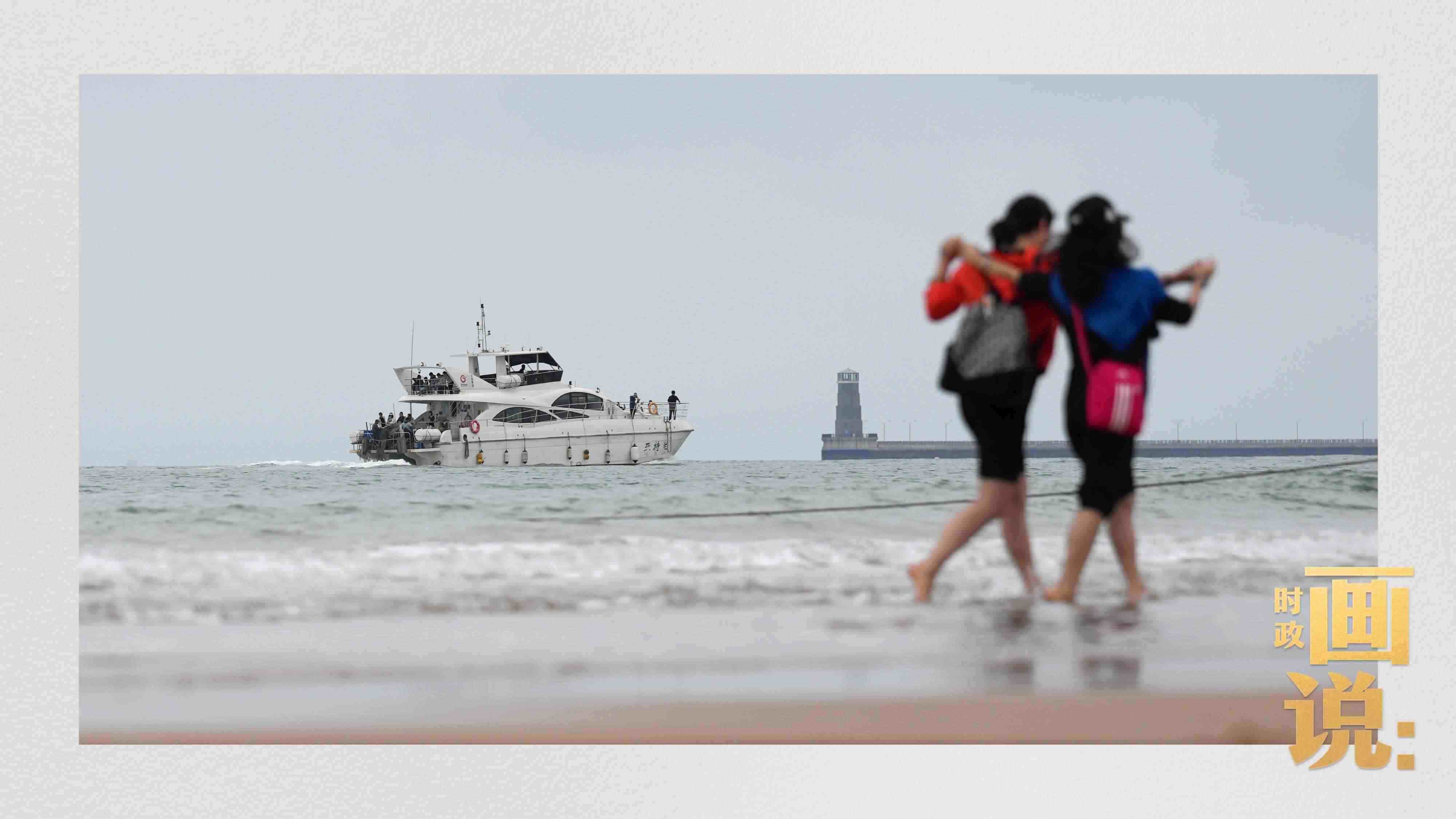 △日照陽光海岸綠道上的萬平口景區(qū)，一對(duì)游客在海浪中翩然起舞。