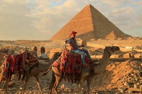 1月24日，商販騎駱駝離開埃及吉薩金字塔景區(qū)。新華社記者 隋先凱 攝