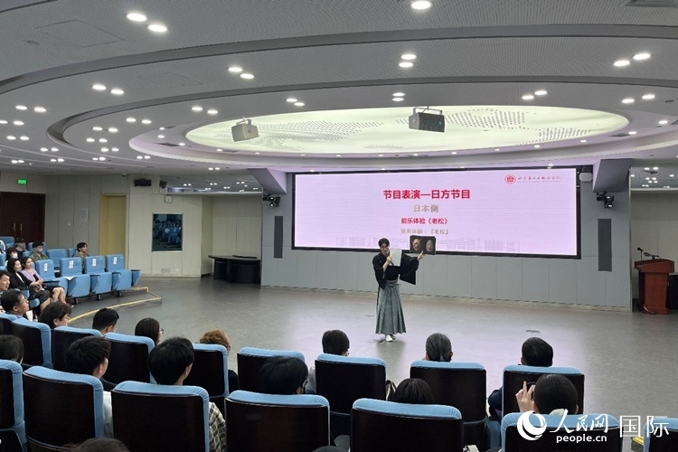 日本大學(xué)生介紹能樂知識。人民網(wǎng)記者 陳思攝