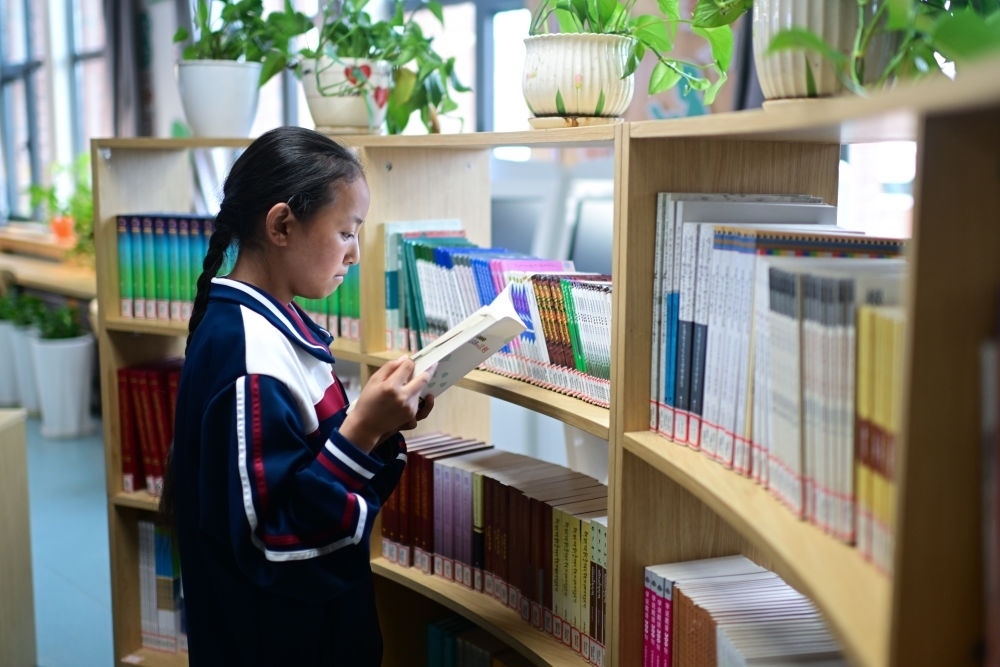 6月18日，果洛西寧民族中學(xué)學(xué)生尼東拉毛在圖書室看書。