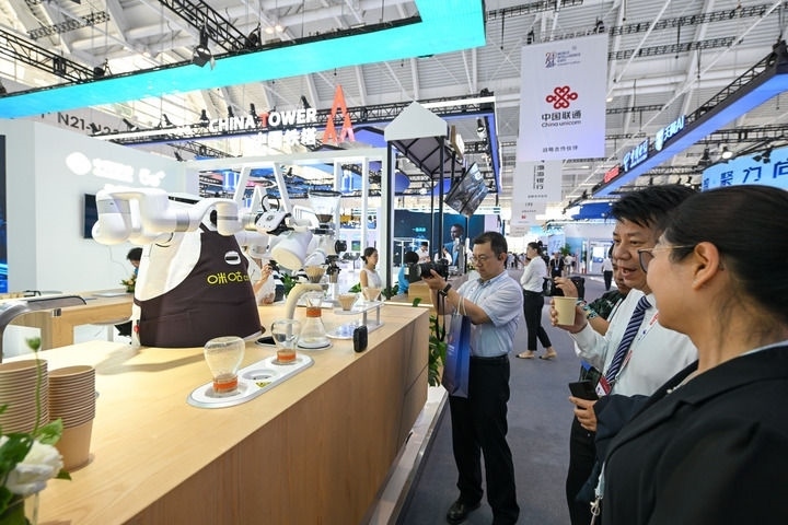 6月20日，與會者品嘗機器人沖調(diào)出的咖啡。新華社記者 孫凡越 攝