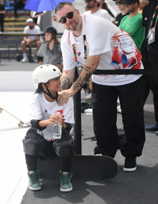 6月20日，鄭好好（左）在比賽間隙與教練互動，她在預(yù)賽中最佳成績?yōu)?2.60分。當(dāng)日，巴黎奧運(yùn)會資格系列賽布達(dá)佩斯站滑板女子碗池預(yù)賽在布達(dá)佩斯舉行。新華社記者 賀燦鈴 攝