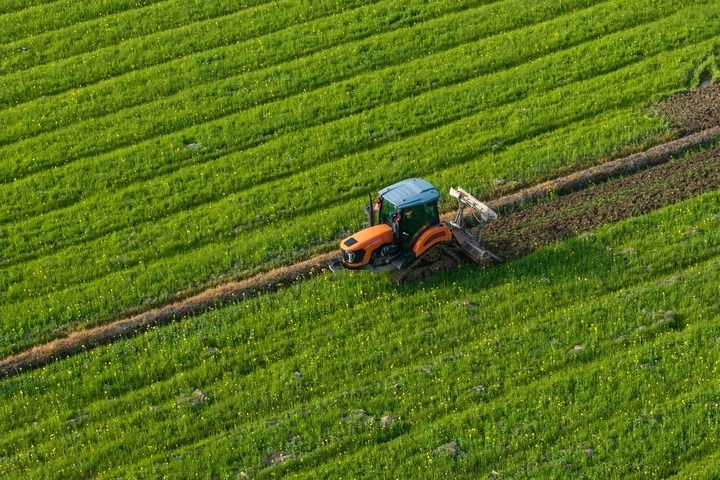 2024年3月19日，在湖南省常德市鼎城區(qū)謝家鋪鎮(zhèn)港中坪村，村民駕駛農(nóng)機(jī)翻耕田地（無人機(jī)照片）。新華社記者 陳思汗 攝