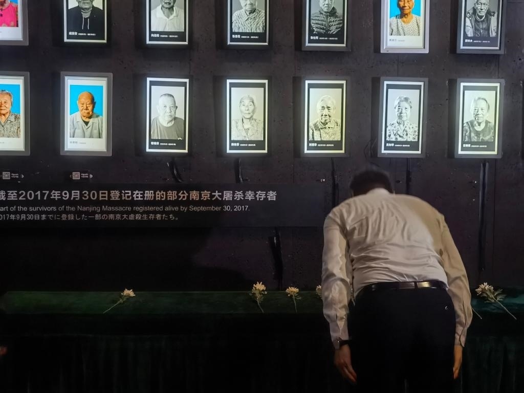 7月18日，人們向離世的南京大屠殺幸存者獻花、鞠躬。新華社記者邱冰清 攝
