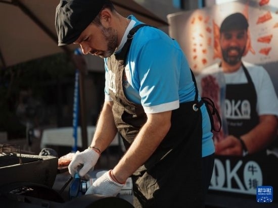 7月19日，在蕪湖古城，馬丁在當天舉行的啤酒節(jié)上制作牛排。新華社發(fā)（繆雨晨 攝）