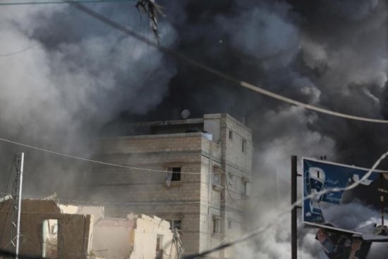 7月21日，在加沙地帶中部的努賽賴特難民營(yíng)，遭以軍空襲的建筑冒出滾滾濃煙。新華社發(fā)（馬爾萬·達(dá)烏德攝）