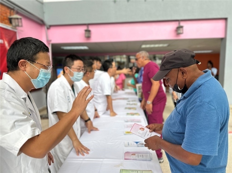 援圭醫(yī)療隊隊員們在啟動儀式上為當地民眾分發(fā)宣傳手冊。中國援助圭亞那醫(yī)療隊供圖