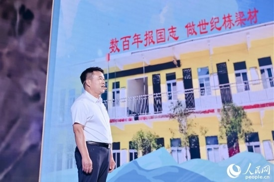 張玉滾分享用一根扁擔(dān)送孩子們走出大山的故事。人民網(wǎng)攝