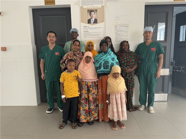 李廣（右一）和王林醫(yī)生與部分患者合影。中國援桑醫(yī)療隊供圖