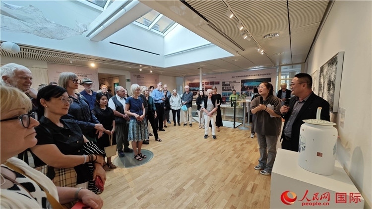 參展人、景德鎮(zhèn)陶瓷大學(xué)美術(shù)學(xué)院副院長(zhǎng)邵長(zhǎng)宗（右一）向來(lái)賓介紹參展作品。人民網(wǎng)記者 殷淼攝