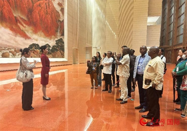 代表團(tuán)在入口處聽取講解。人民網(wǎng) 曹欣悅攝