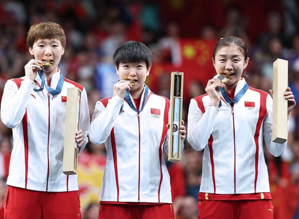 冠軍中國隊選手王曼昱、孫穎莎、陳夢（從左至右）在巴黎奧運會乒乓球女子團體頒獎儀式上（2024年8月10日攝）。新華社記者 王東震 攝