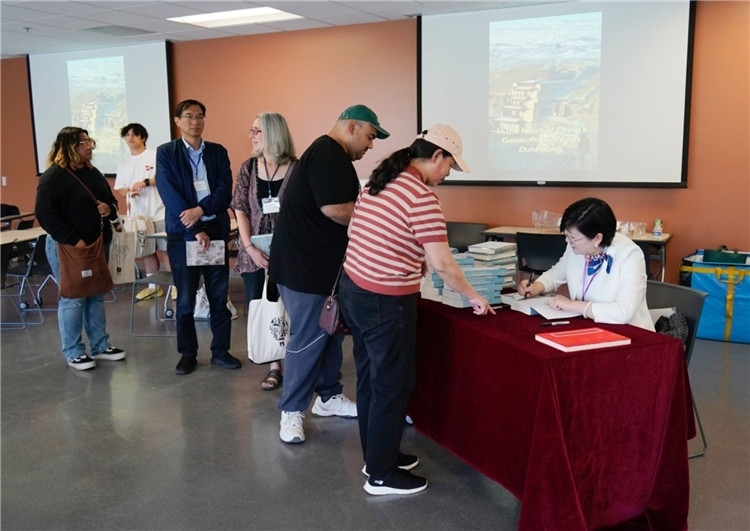 作者顧春芳在活動現(xiàn)場簽名贈書。羅先勇攝