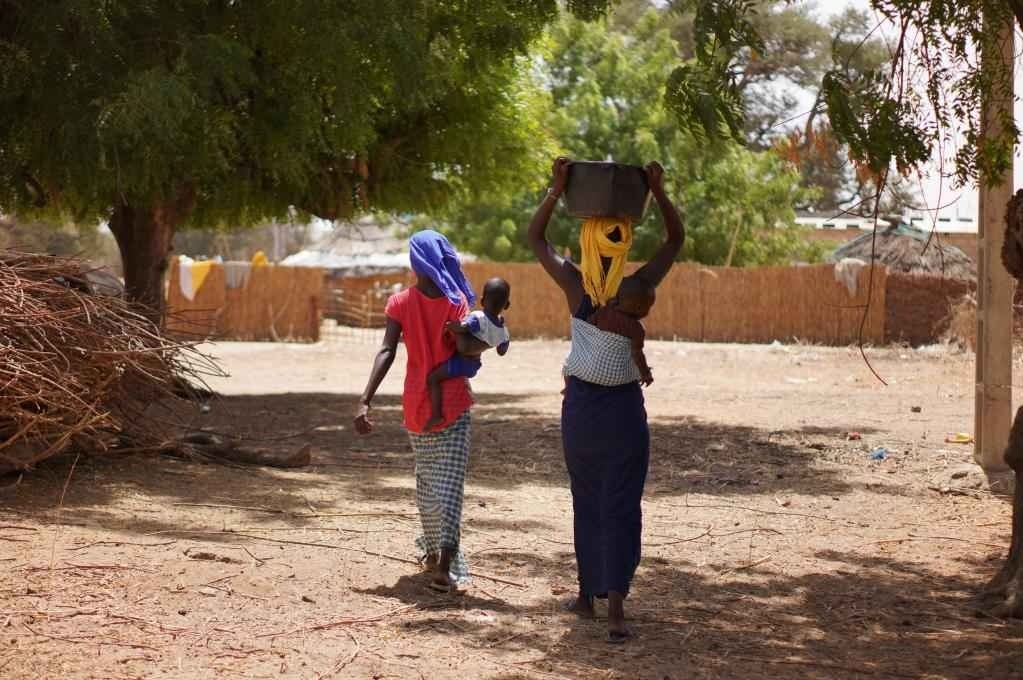 2023年3月20日，在塞內(nèi)加爾久爾貝勒區(qū)的泰內(nèi)富勒村，村民將取到的水運(yùn)回家。新華社記者 王子正 攝