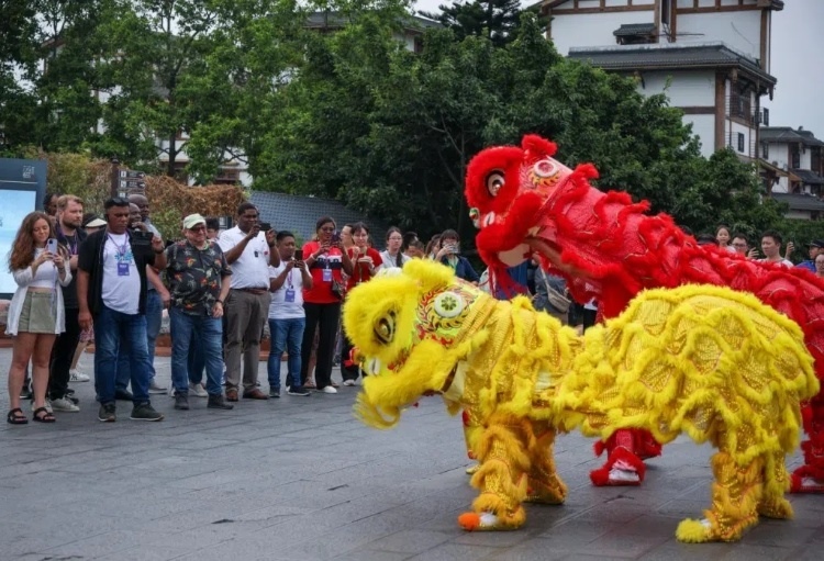 2024“一帶一路”媒體合作論壇聯(lián)合采訪調(diào)研行成員在樂山蘇稽古鎮(zhèn)觀看非遺舞獅表演。本報記者 伊霄攝