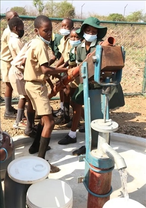 △2021年11月，在津巴布韋南馬塔貝萊蘭省省會關(guān)達(dá)的塞農(nóng)多小學(xué)，學(xué)生從中國援建水井里打水。