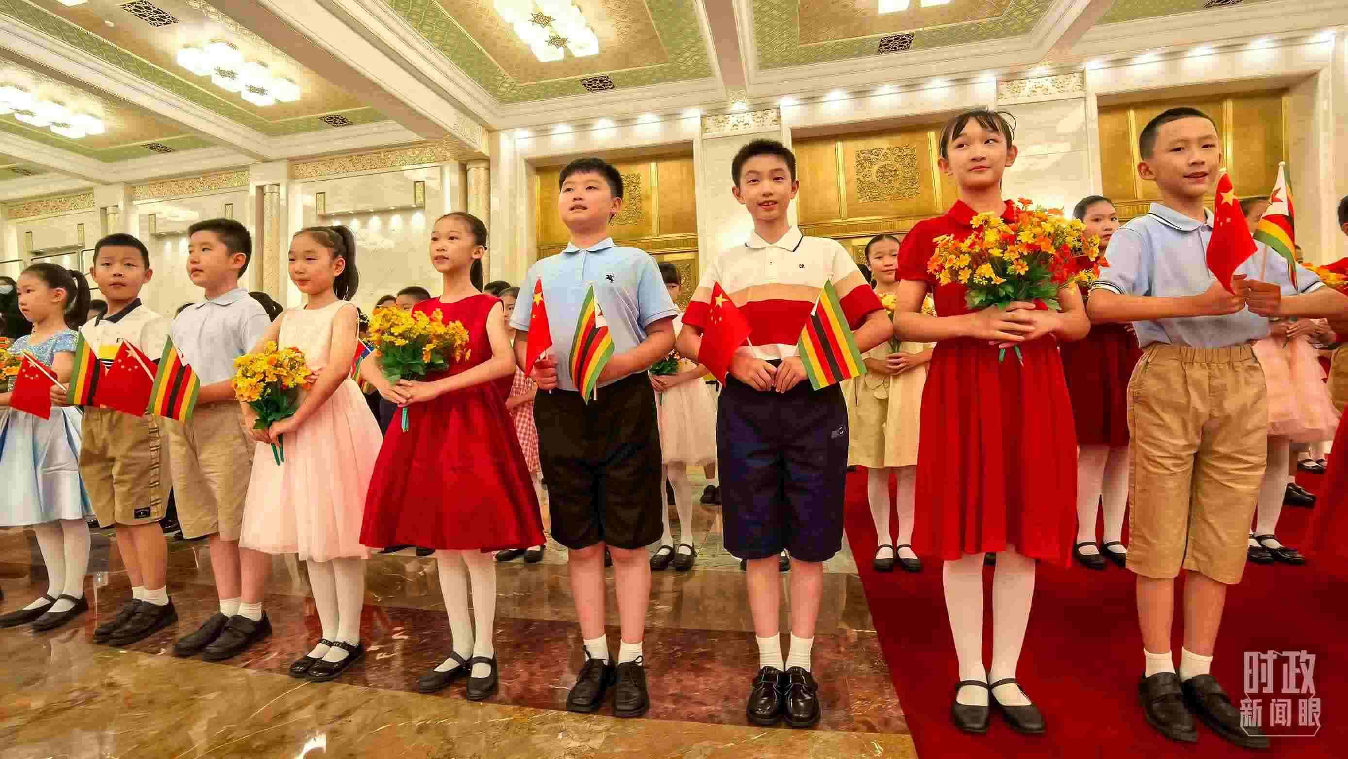 △現(xiàn)場(chǎng)歡迎津巴布韋總統(tǒng)訪華的青少年。（總臺(tái)央視記者鐘銳拍攝）