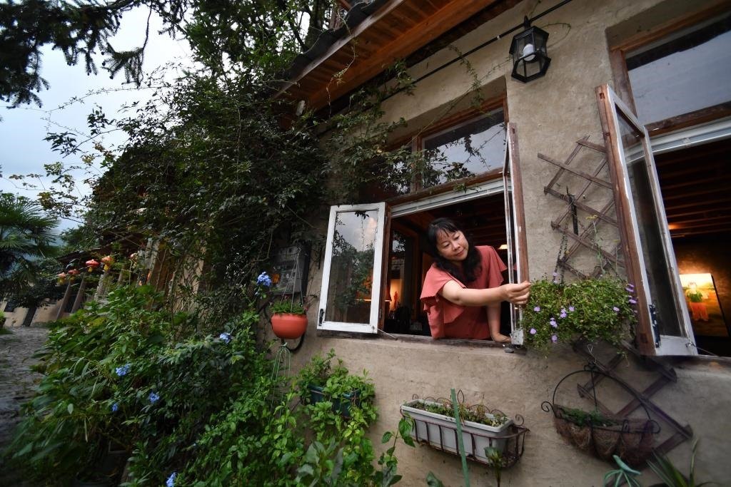 8月29日，在福建省屏南縣熙嶺鄉(xiāng)，龍?zhí)洞濉靶麓迕瘛泵泛暝诖蚶碜约航?jīng)營(yíng)的民宿外墻裝飾花盆。新華社記者姜克紅 攝