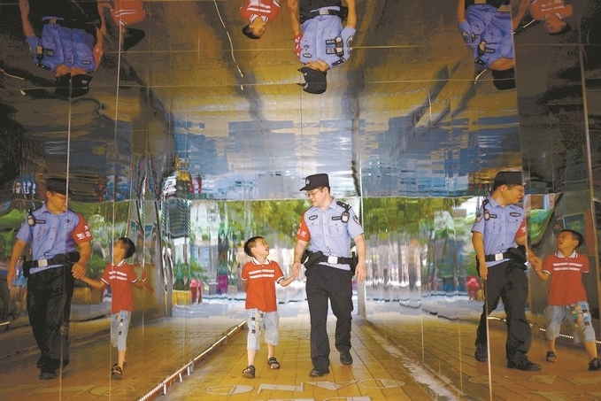 ?7月16日，重慶市公安局江北區(qū)分局一名民警在巡邏途中遇到一個獨(dú)自玩耍的小男孩，民警將其送回家。王洪平攝