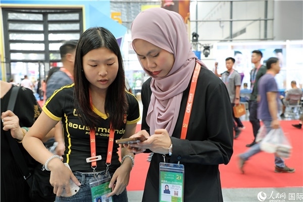 東博會現(xiàn)場，馬來西亞展商在同中方工作人員交談。人民網(wǎng)記者 趙益普攝