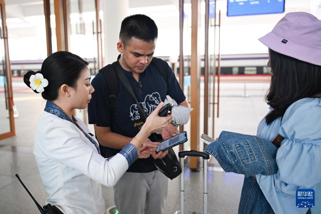 10月12日，在老撾萬象中老鐵路萬象站，工作人員檢驗乘客車票。新華社記者 程一恒 攝