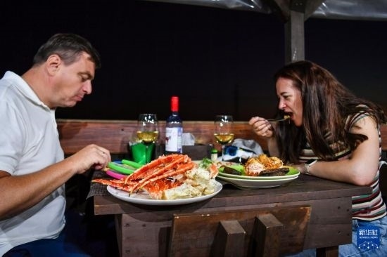 9月2日，食客們在俄羅斯符拉迪沃斯托克的一家餐館品嘗帝王蟹。新華社記者 曹陽 攝