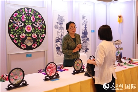 青海非遺文化傳承人向嘉賓介紹展品。人民網(wǎng)實習(xí)生姚欣可攝