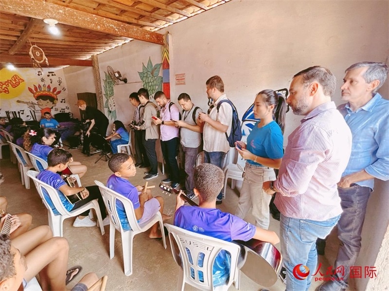  受益于中國企業(yè)的“青少年成長”項(xiàng)目，700多名當(dāng)?shù)厍嗌倌甑囊魳泛妥闱驂粝氩迳狭顺岚?。圖為聯(lián)合采訪團(tuán)正在采訪參加音樂培訓(xùn)的孩子們。 人民網(wǎng)記者 陳一鳴攝