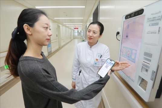 醫(yī)護人員引導患者在自助機前辦理自助入院手續(xù)。圖片來源：山東第一醫(yī)科大學第二附屬醫(yī)院