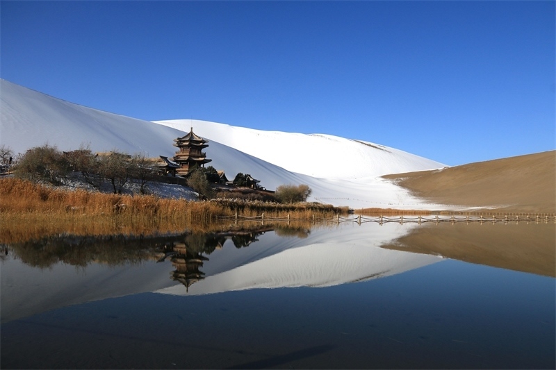 鳴沙山月牙泉景區(qū)雪景。敦煌市委宣傳部供圖，張曉亮攝