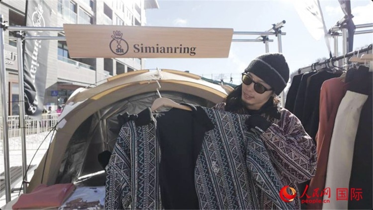 藤田周正在展示自己設(shè)計(jì)的滑雪服。人民網(wǎng)記者 袁蒙攝