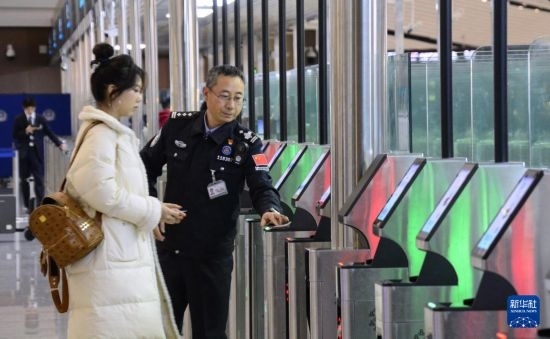1月2日，大興機場邊檢站警察指導旅客使用自助出境設備。新華社記者 李欣 攝