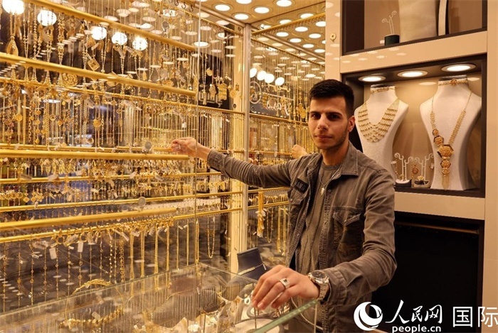 一名銷售員展示黃金飾品。人民網(wǎng) 伊納斯·易卜拉欣攝