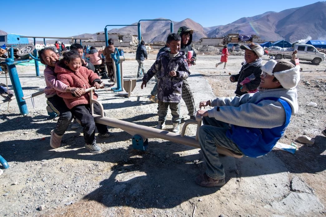 1月11日，在定日縣措果鄉(xiāng)塘仁村安置點(diǎn)，西藏星光社會(huì)工作服務(wù)中心志愿者和孩子們一起玩耍，進(jìn)行災(zāi)后心理疏導(dǎo)。人民網(wǎng)記者 翁奇羽攝
