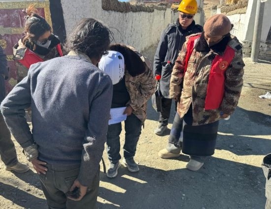 1月13日，次旺（右一）陪同工作組走訪村莊，評估房屋受損程度。新華社發(fā)