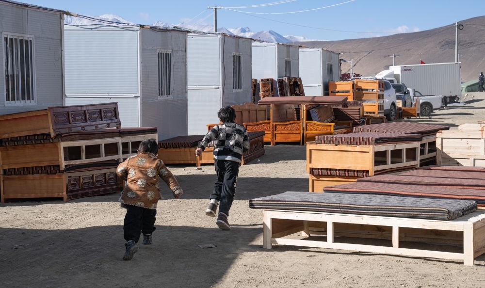 2025年1月13日，在定日縣嘎旦村，兩個孩子在剛運來的兩排藏床間奔跑。新華社記者丁增尼達(dá) 攝