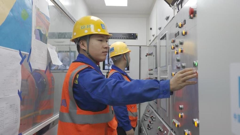 盾構(gòu)司機(jī)何曉波在駕駛室內(nèi)調(diào)試盾構(gòu)機(jī)參數(shù)。（劉芬攝）