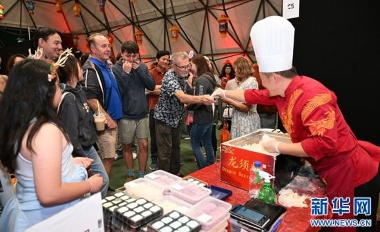 圖為游客在燈節(jié)現(xiàn)場(chǎng)購(gòu)買(mǎi)小吃。（圖片由奧克蘭中國(guó)文化中心提供）