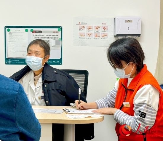 秦苑（中）接診患者。人民網(wǎng)記者 金慧慧攝