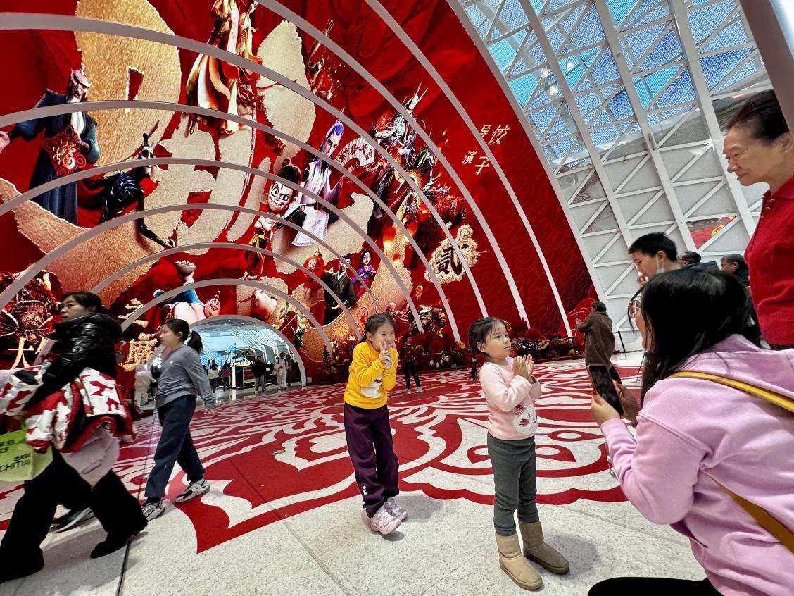 乙巳蛇年春節(jié)期間，影迷在《哪吒之魔童鬧?！肪薹?bào)前拍照打卡。